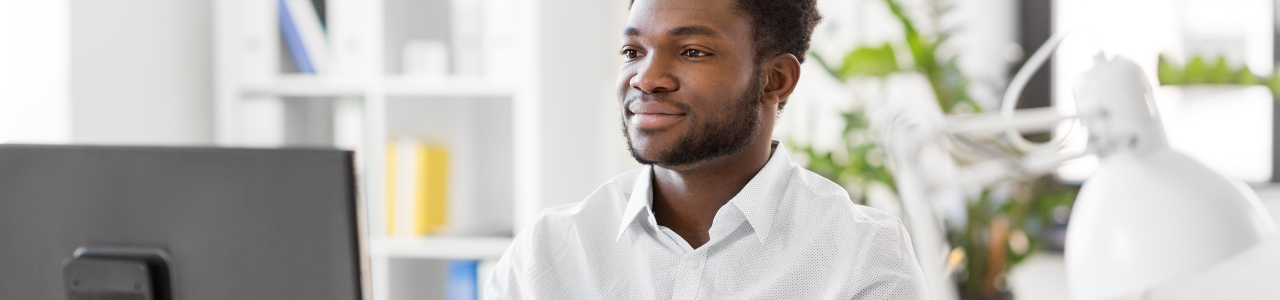 businessman sitting behind computer desk in home office